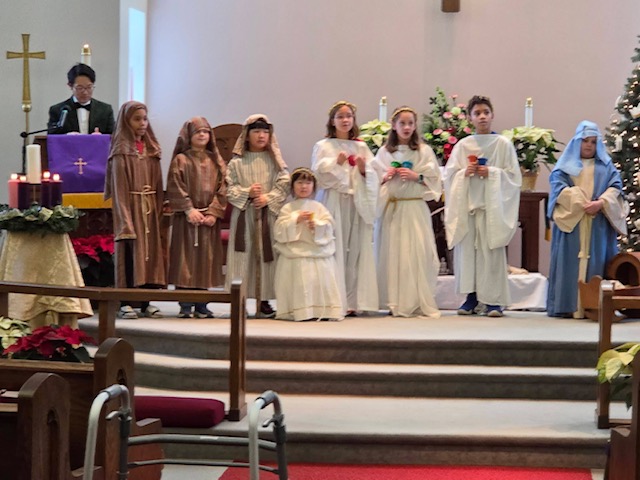 Children dressed as nativity characters for a Christmas pageant in the sanctuary