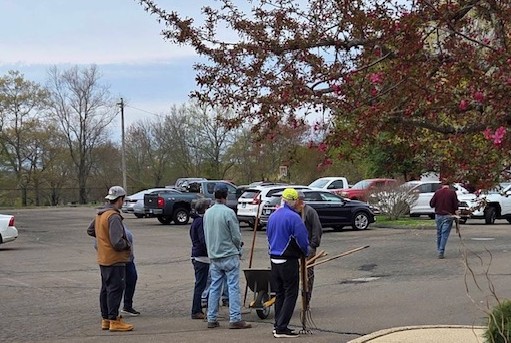 Trustees gathered with rakes and wheelbarrow for grounds work